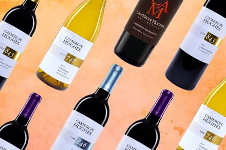 A sampling of Cameron Hughes Wine bottles on an orange background.