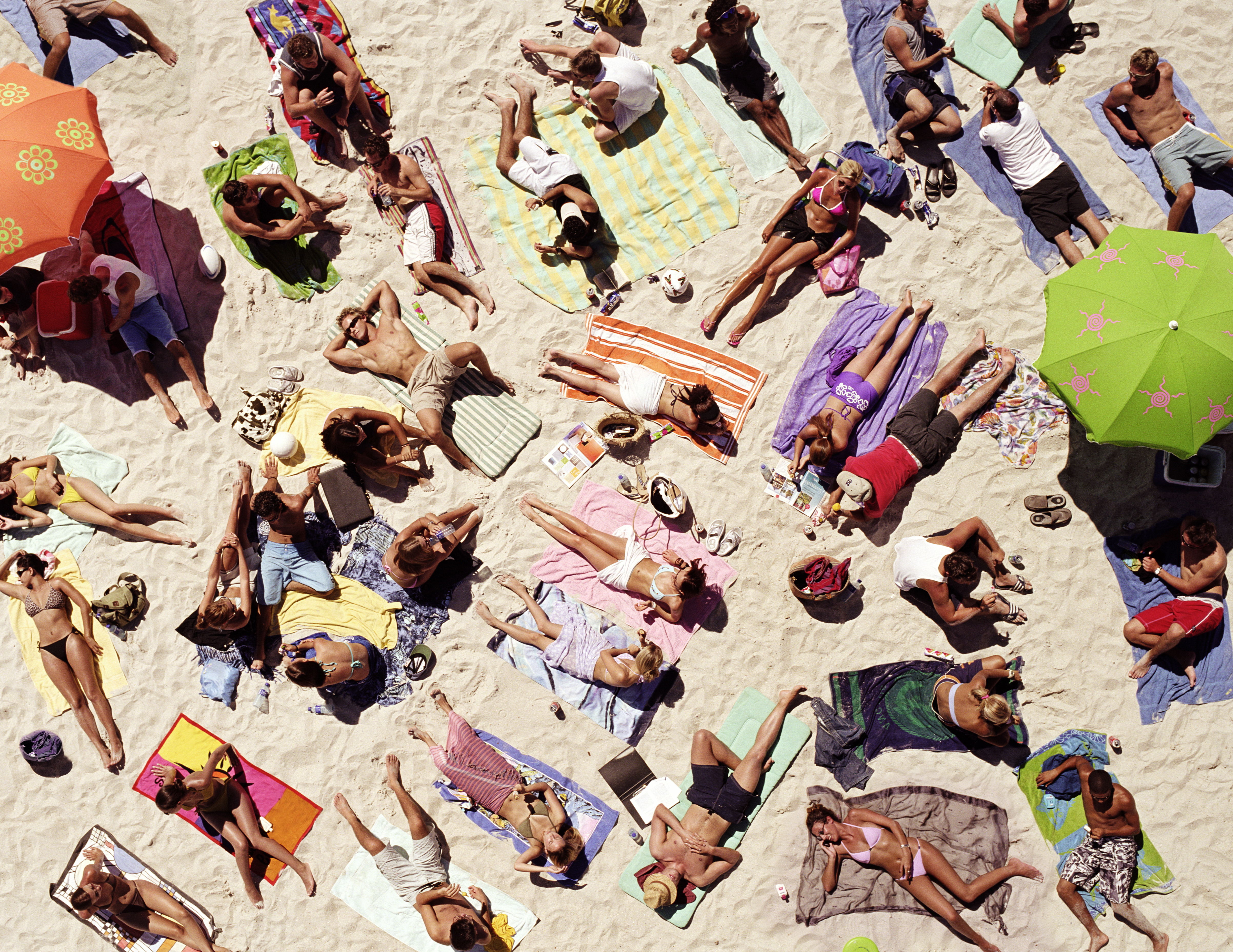 A crowd of sunbathers on the beach seen from a bird's-eye view