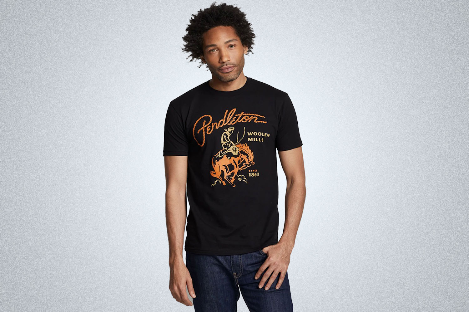 a model in a black graphic rodeo tee from Pendleton on a grey background