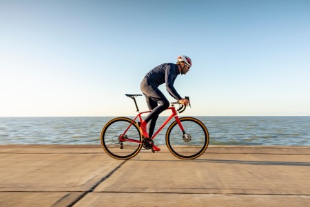 Mature cyclist riding bicycle on coastal path, Kent, United Kingdom