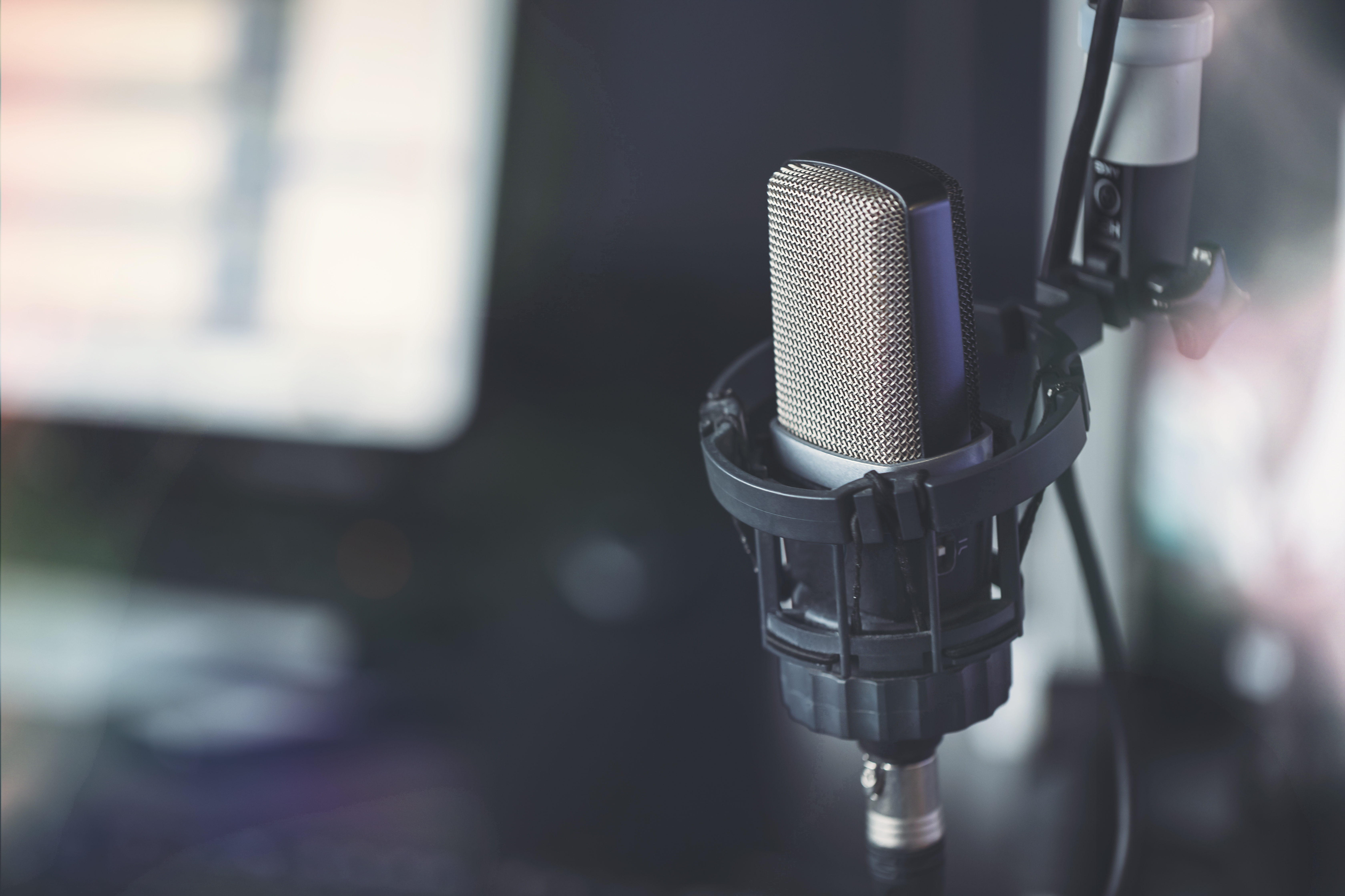 A close-up of a podcasting microphone in a recording studio