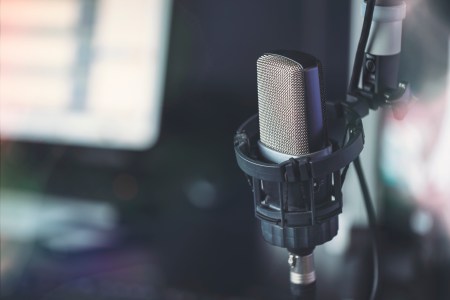 A close-up of a podcasting microphone in a recording studio