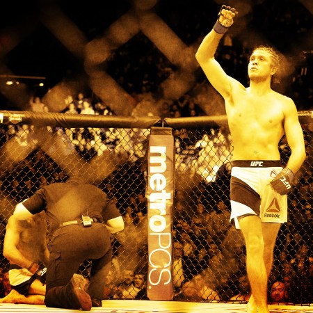 Brian Ortega holds his arm up in triumph in the Octagon.