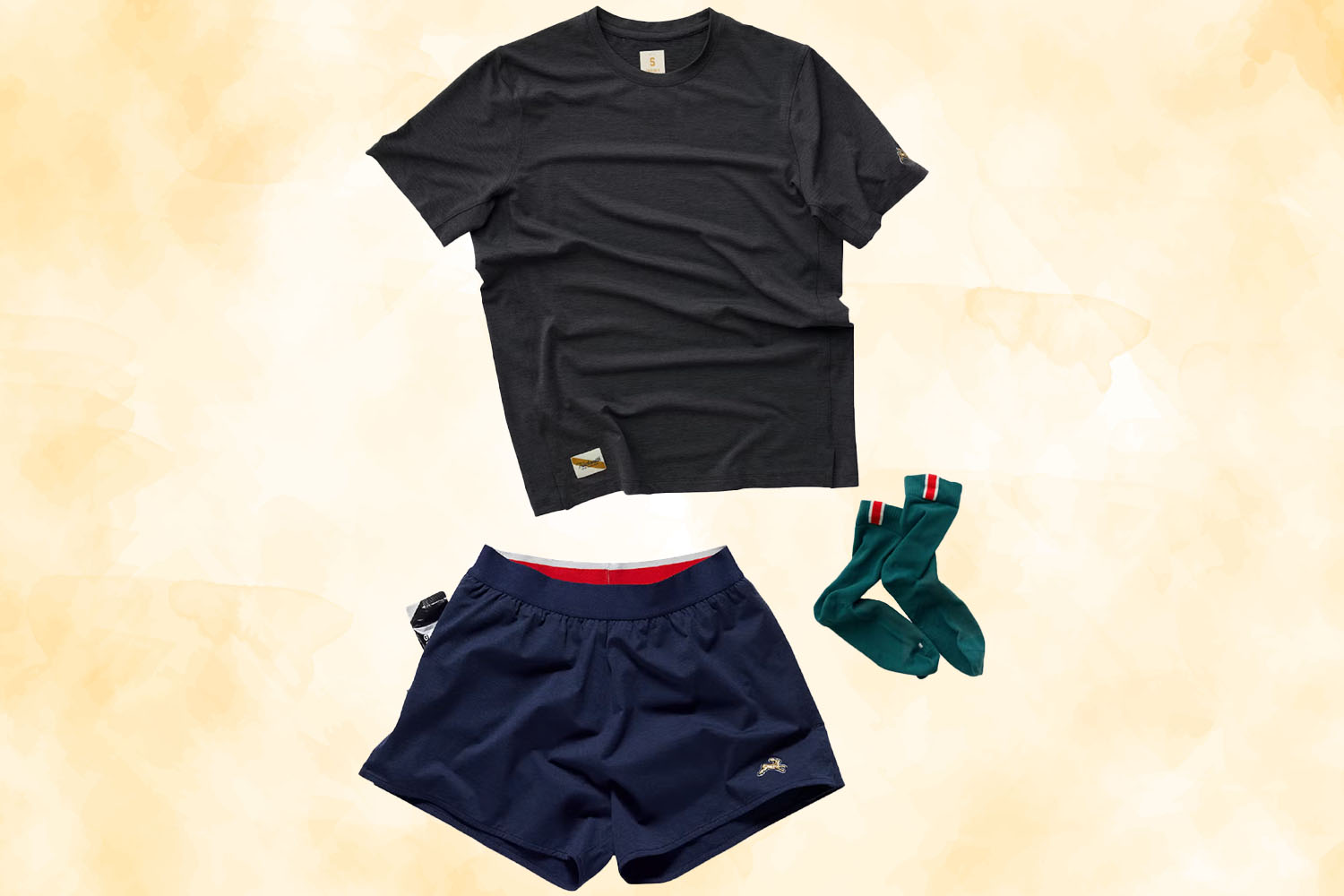 a Distance Training kit with a dark grey shirt, navy shorts and green socks from Tracksmith on a gold textured background
