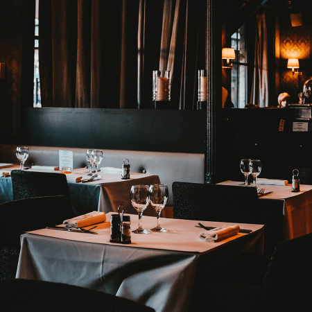 An empty restaurant with tables set for dinner