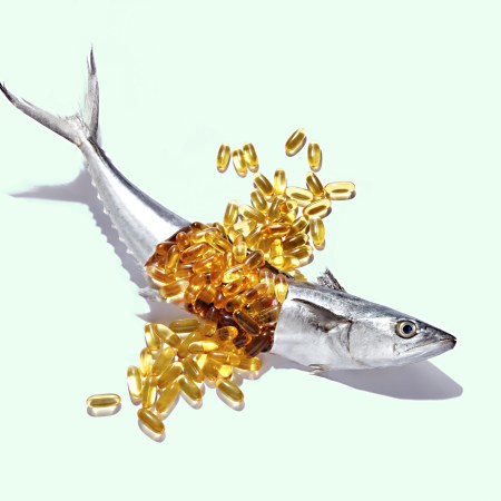 A fish cut open to reveal a dozen fish oil capsules.