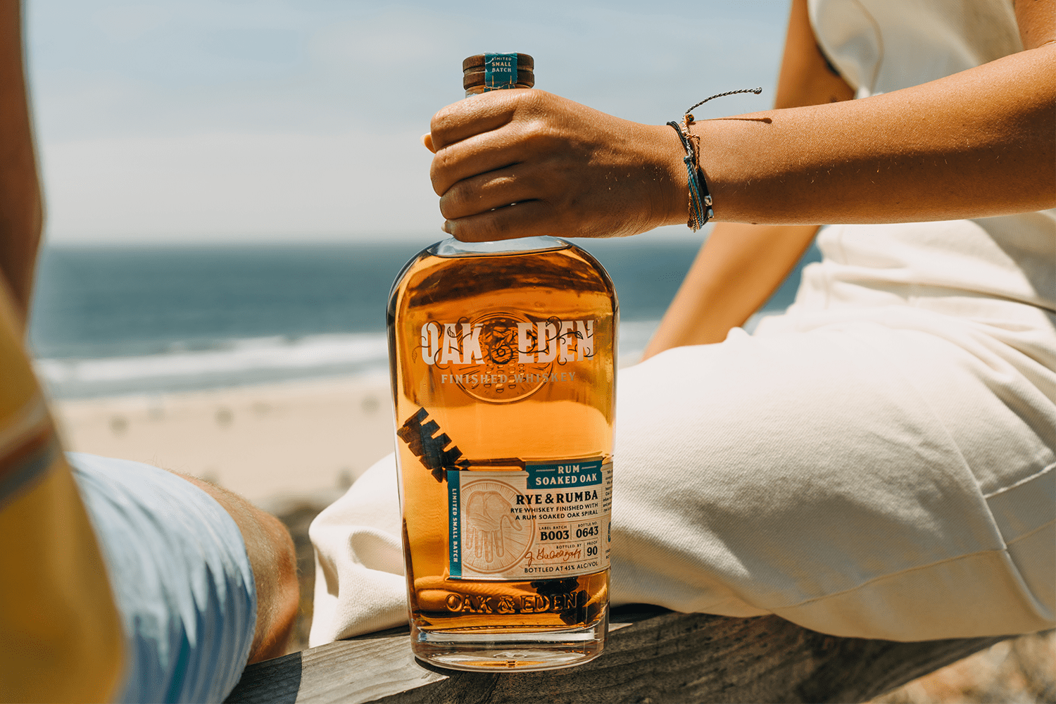 A person holding a bottle of Rye & Rumba whiskey from Oak & Eden