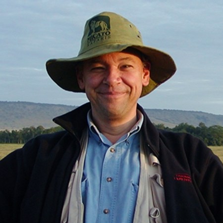 Travel writer and editor Don George in a hat photographed in the countryside