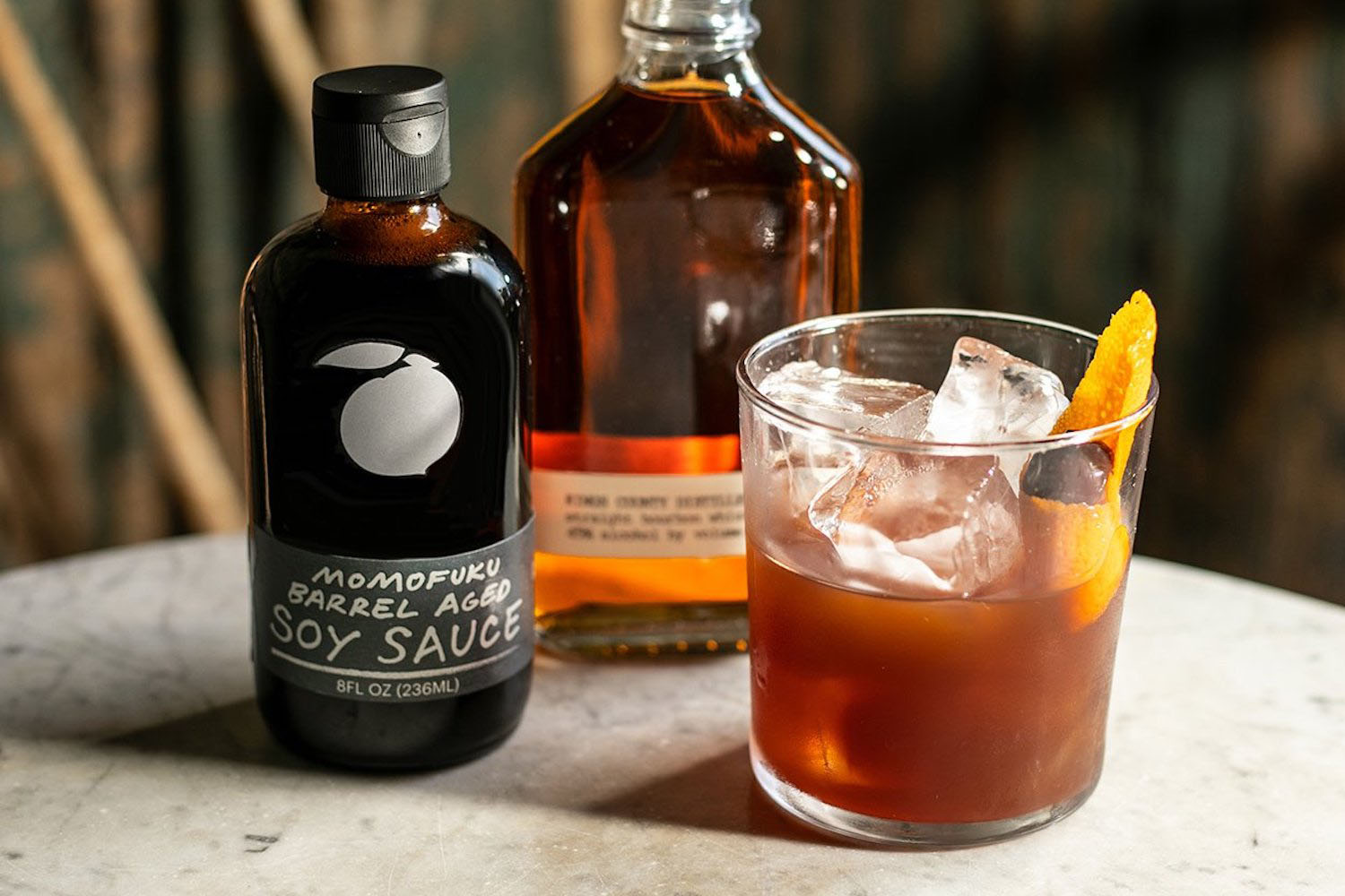 a few bottles of momofuku barrel aged soy sauce on a marble countertop