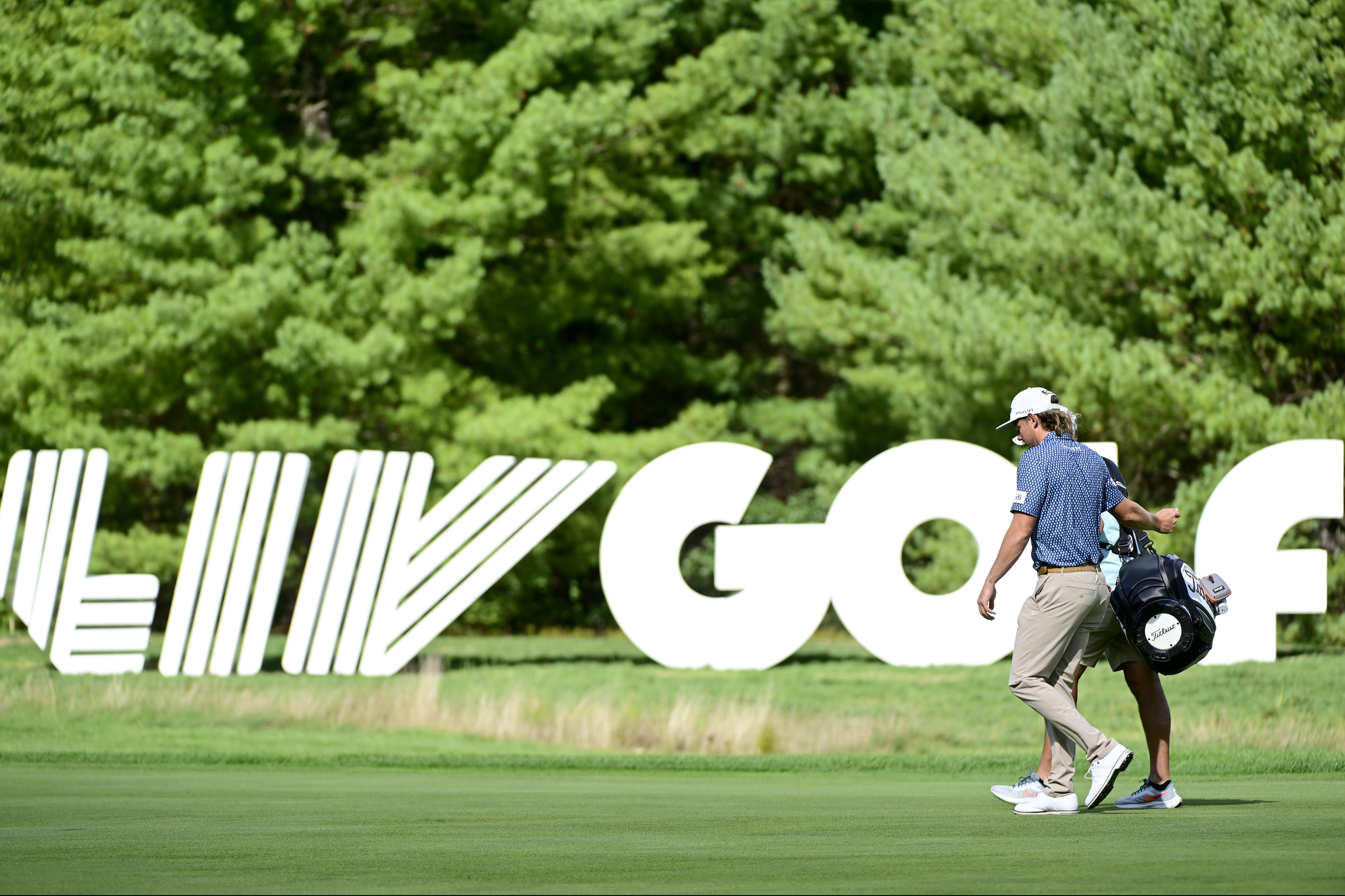 PGA Tour defector Cameron Smith seen prior to the LIV Golf Invitational in Boston, walking in front of a huge LIV Golf sign