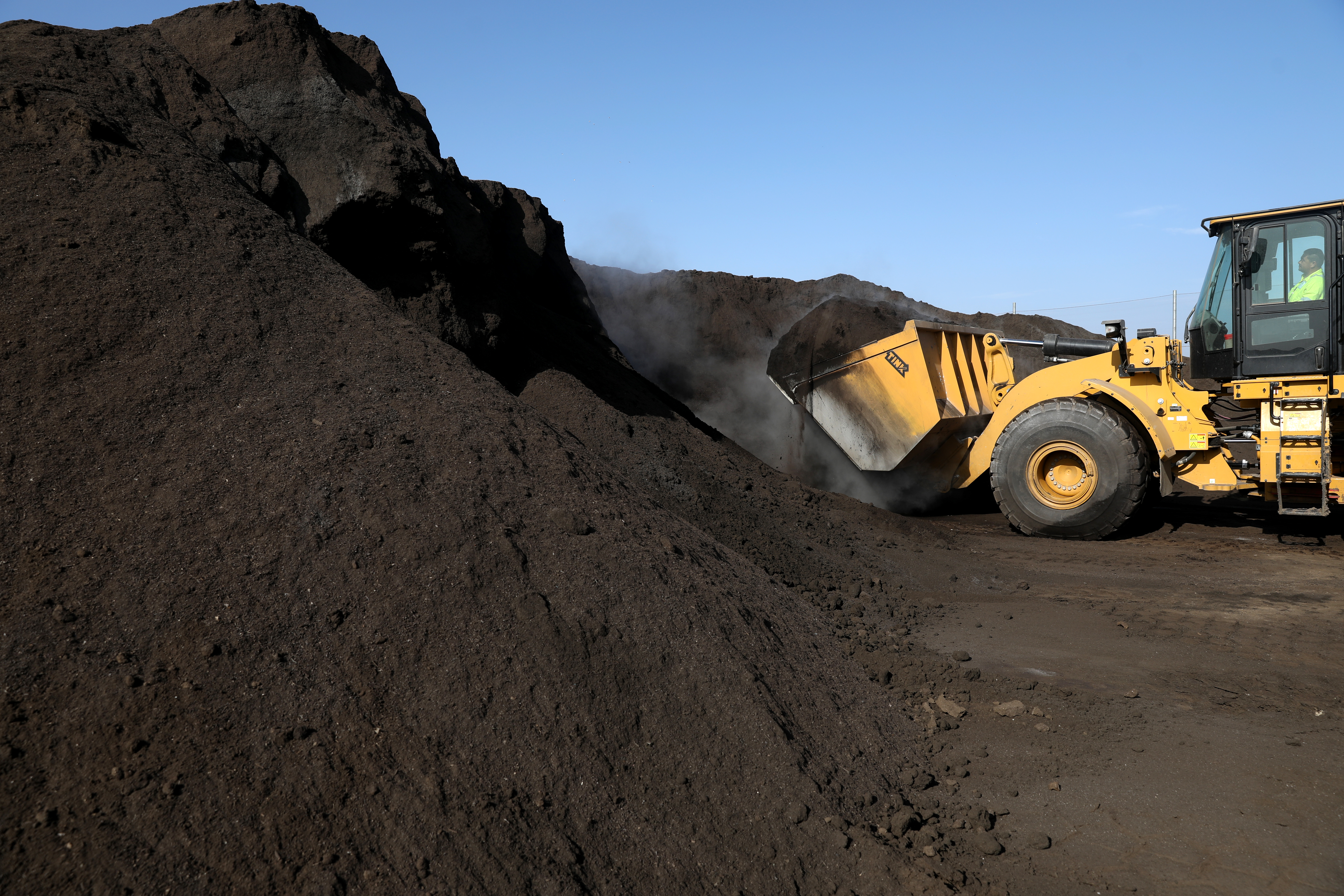 A truck approaches a pile of organic waste in California.