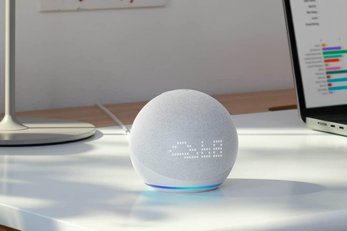 Amazon Echo Dot on a desk showing the weather