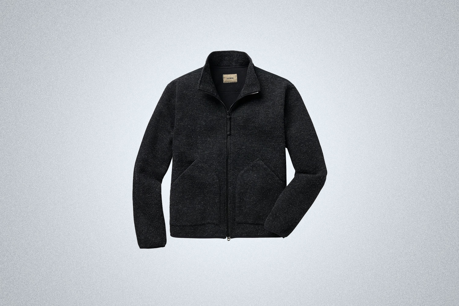 The Buck Mason Alpine Merino Fleece Pack Jacket on a gray background