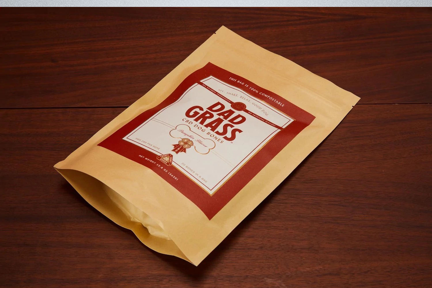 a packet of Dad Grass CBD Dog bones on a dark wooden surface