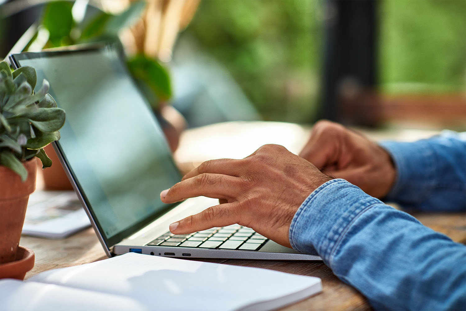 A pair of hands typing on a laptop keyboard