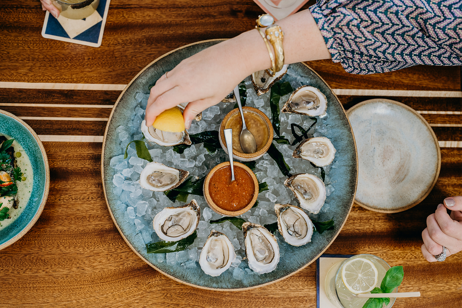 A woman squirting lemon juice on a tray of oysters at The Longboard in Sullivan's Island near Charleston, South Carolina