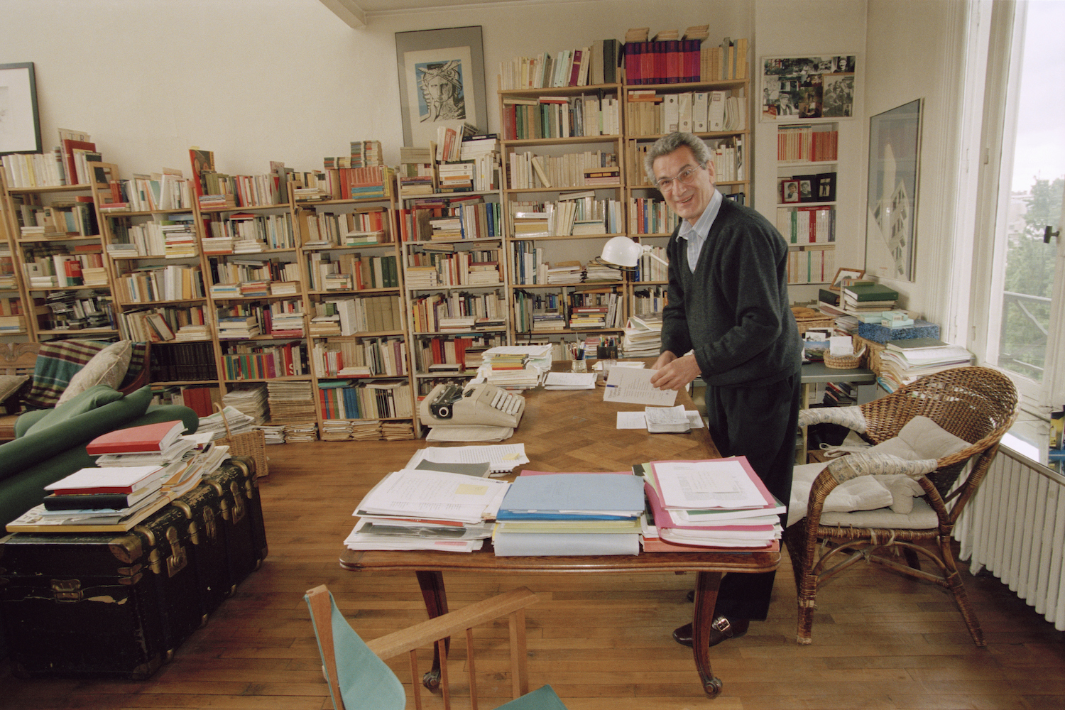 An Italian writer standing in a home library.