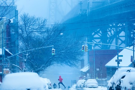A man running through the snow in New York City.