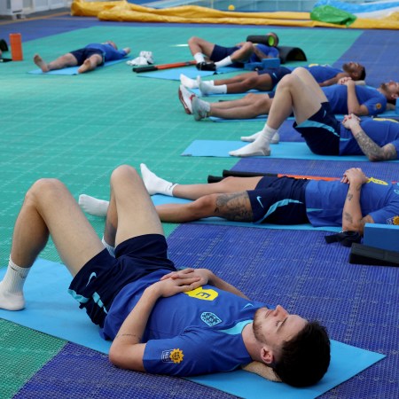 The England national team stretching out on mats.