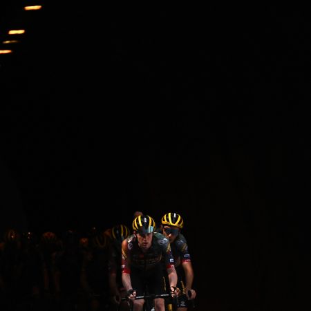 A Belgian cycling team emerges from a dark tunnel.