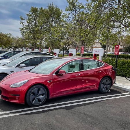 A row of Tesla electric vehicles filling their batteries at charging stations