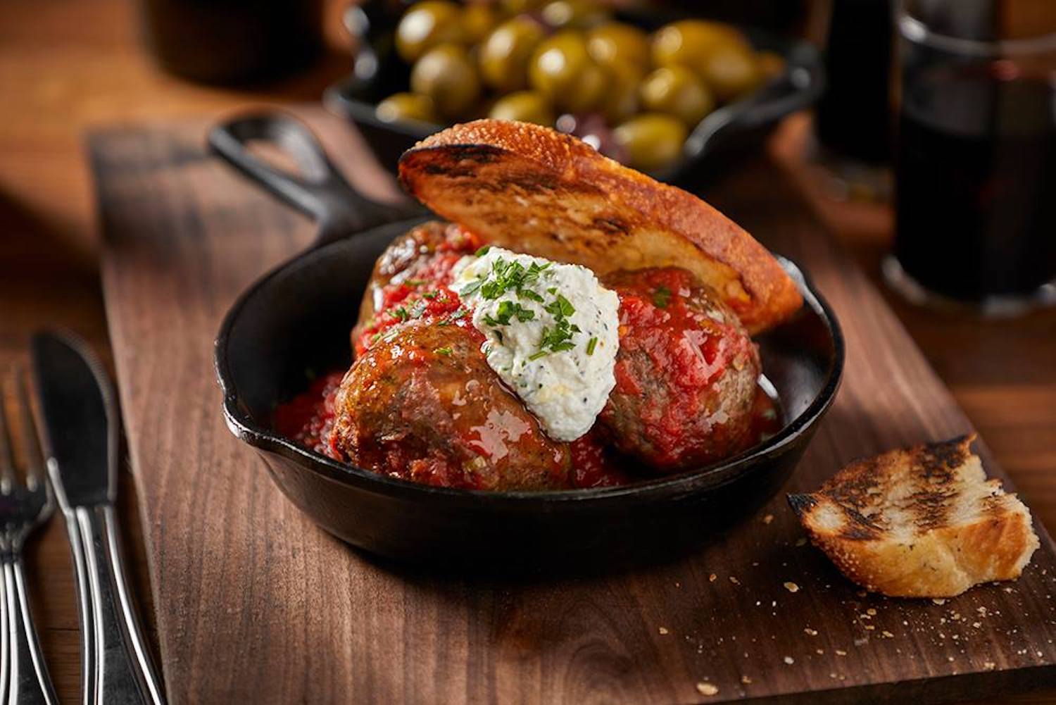 Meatballs on a skillet with cheese and sauce