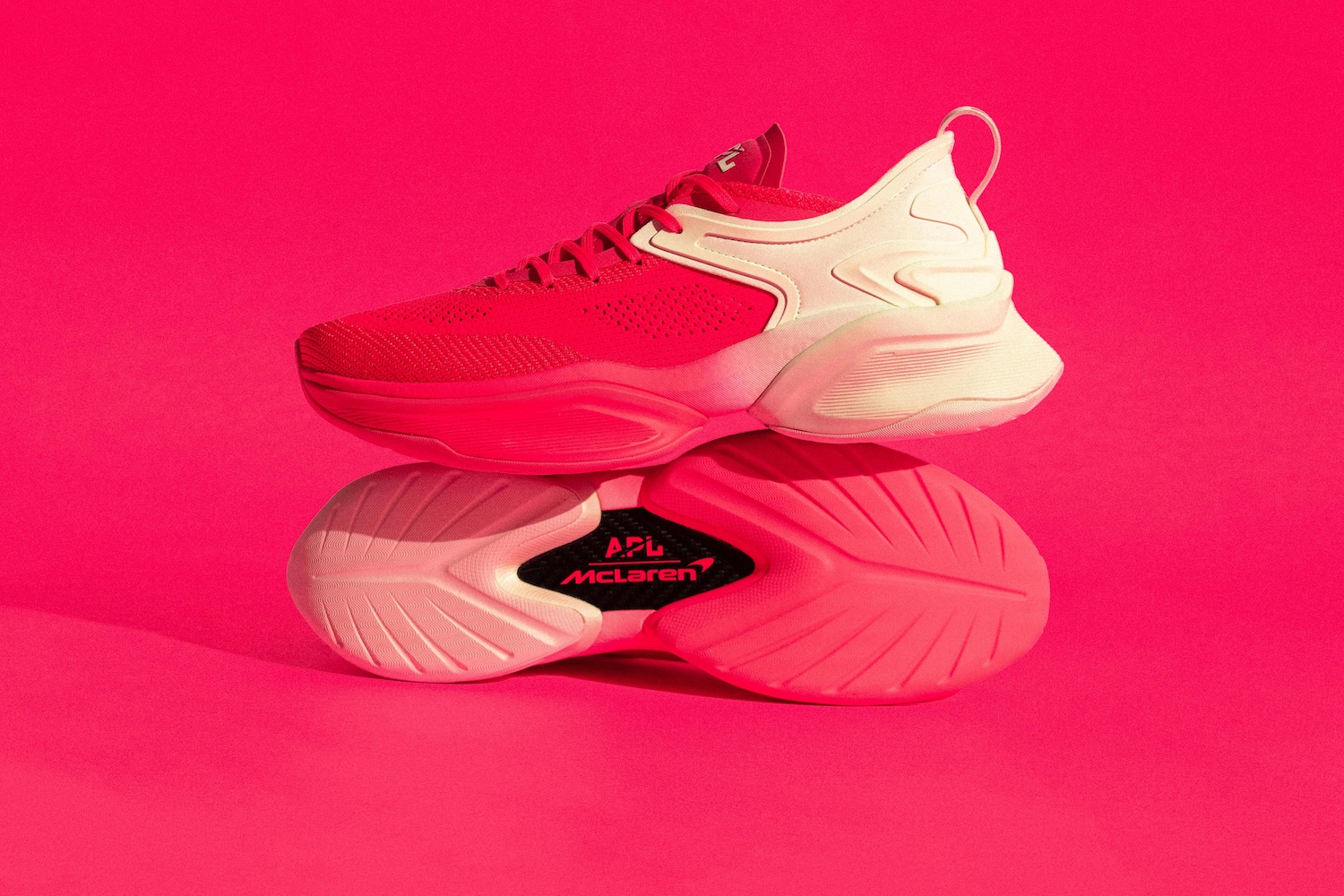 a pink APL shoe on a grey background