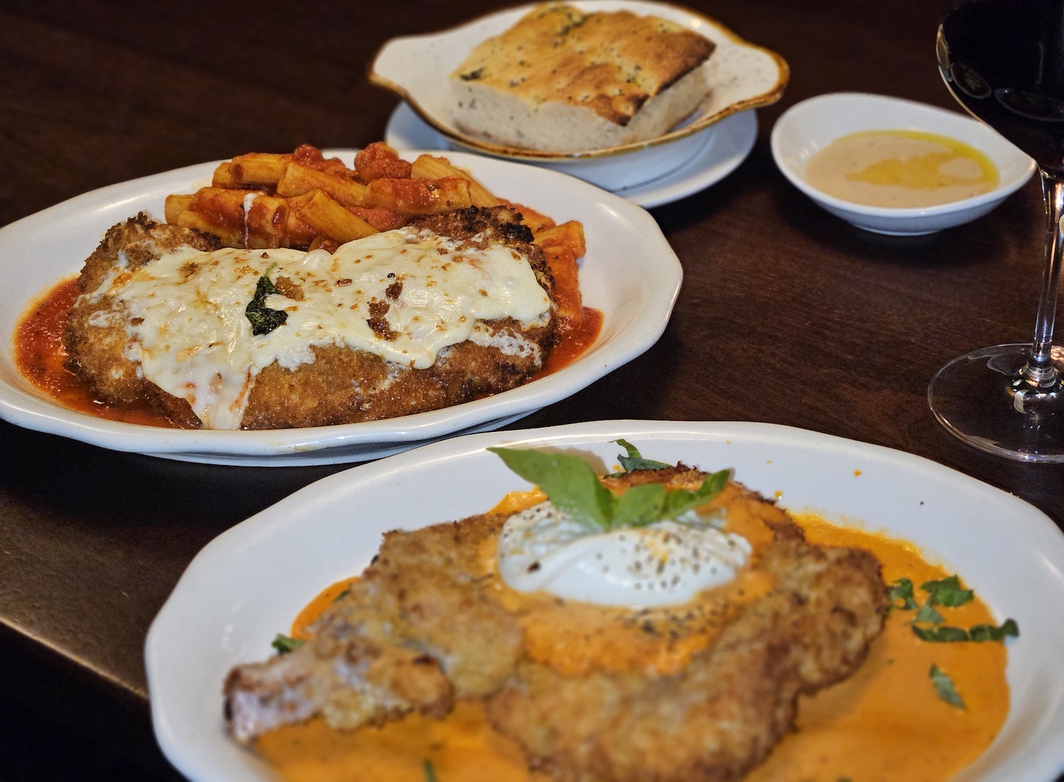 A chicken, pasta and bread dish on a table