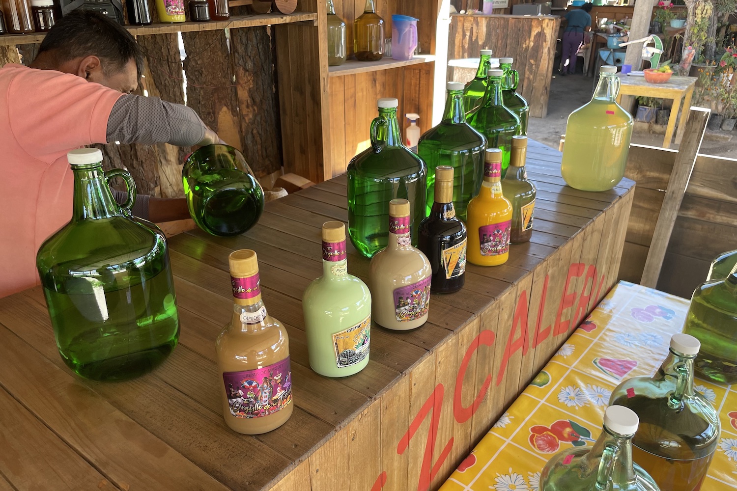 pouring mezcal into a glass at comedor ocho de diciembre