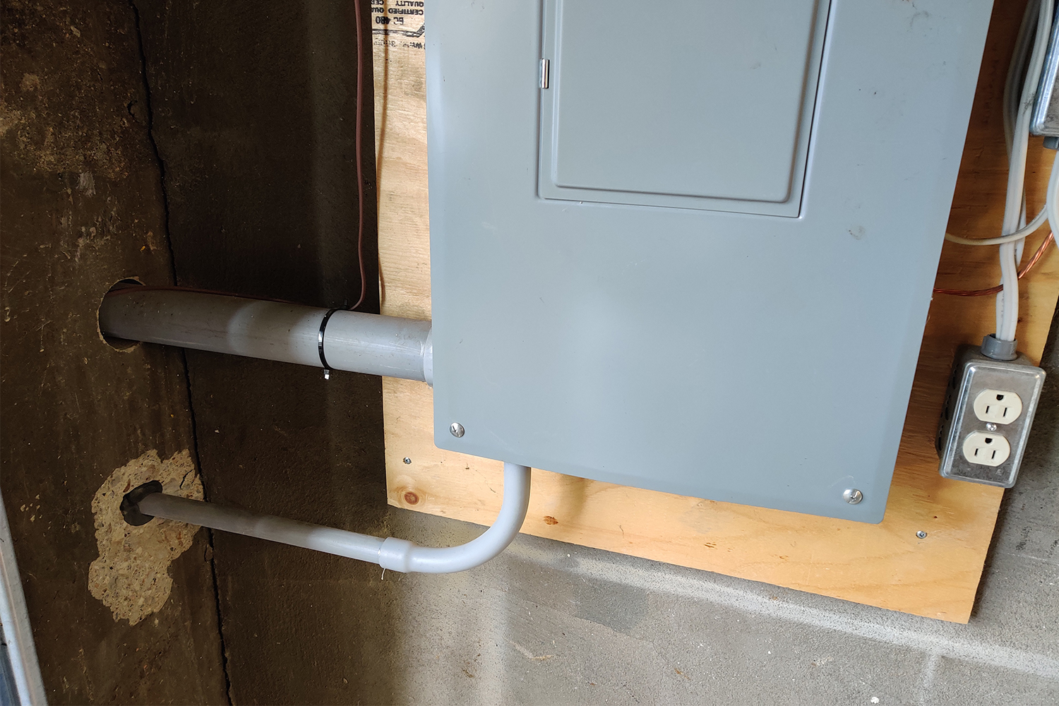 An electrical panel with a hard-wired EV charger connected through a garage wall