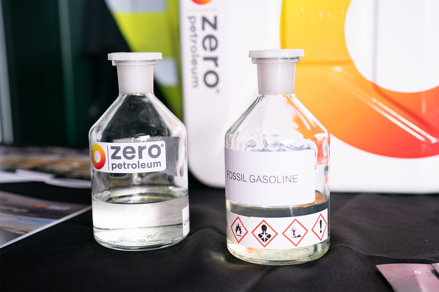 A bottle of synthetic fuel from Zero Petroleum next to a bottle of fossil fuel gasoline