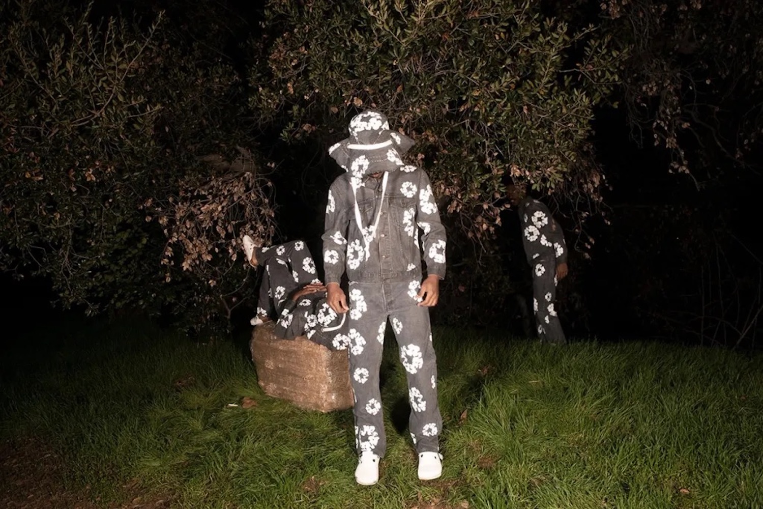 a model at night in Denim Tears clothing