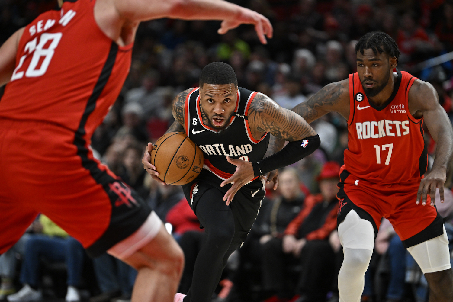 Damian Lillard drives to the hoop between two defenders.