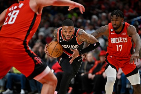 Damian Lillard drives to the hoop between two defenders.