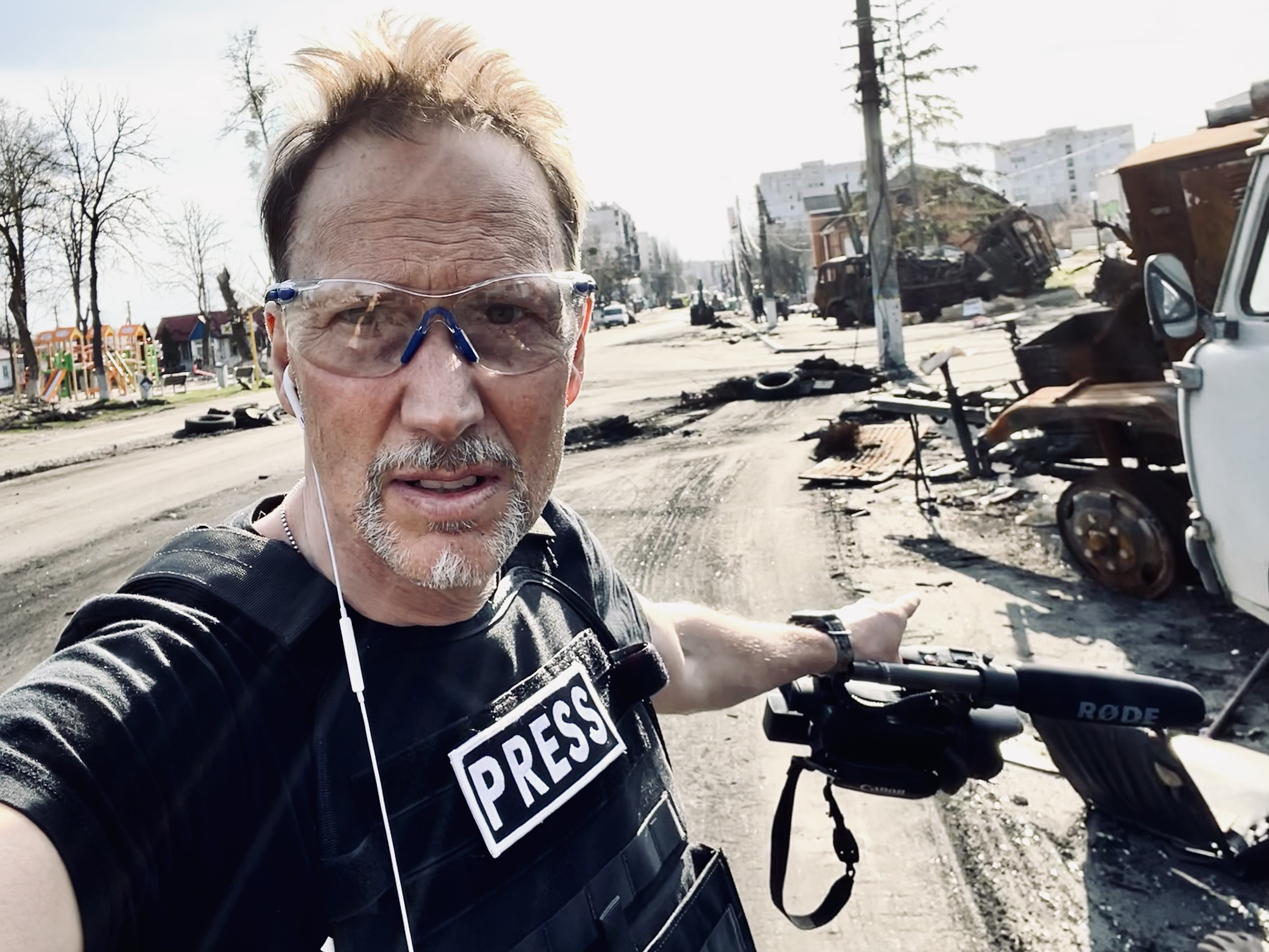 a man in a conflict zone with a press t-shirt