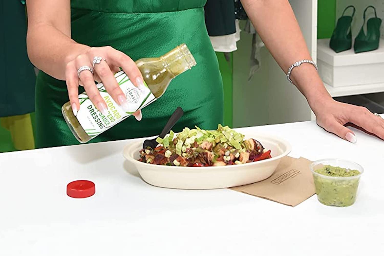 a model pour Tabasco x Tinx Sauce on a burrito bowl