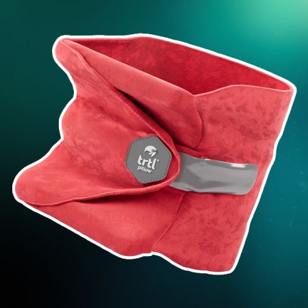 The Trtl Travel neck pillow on a green and red background