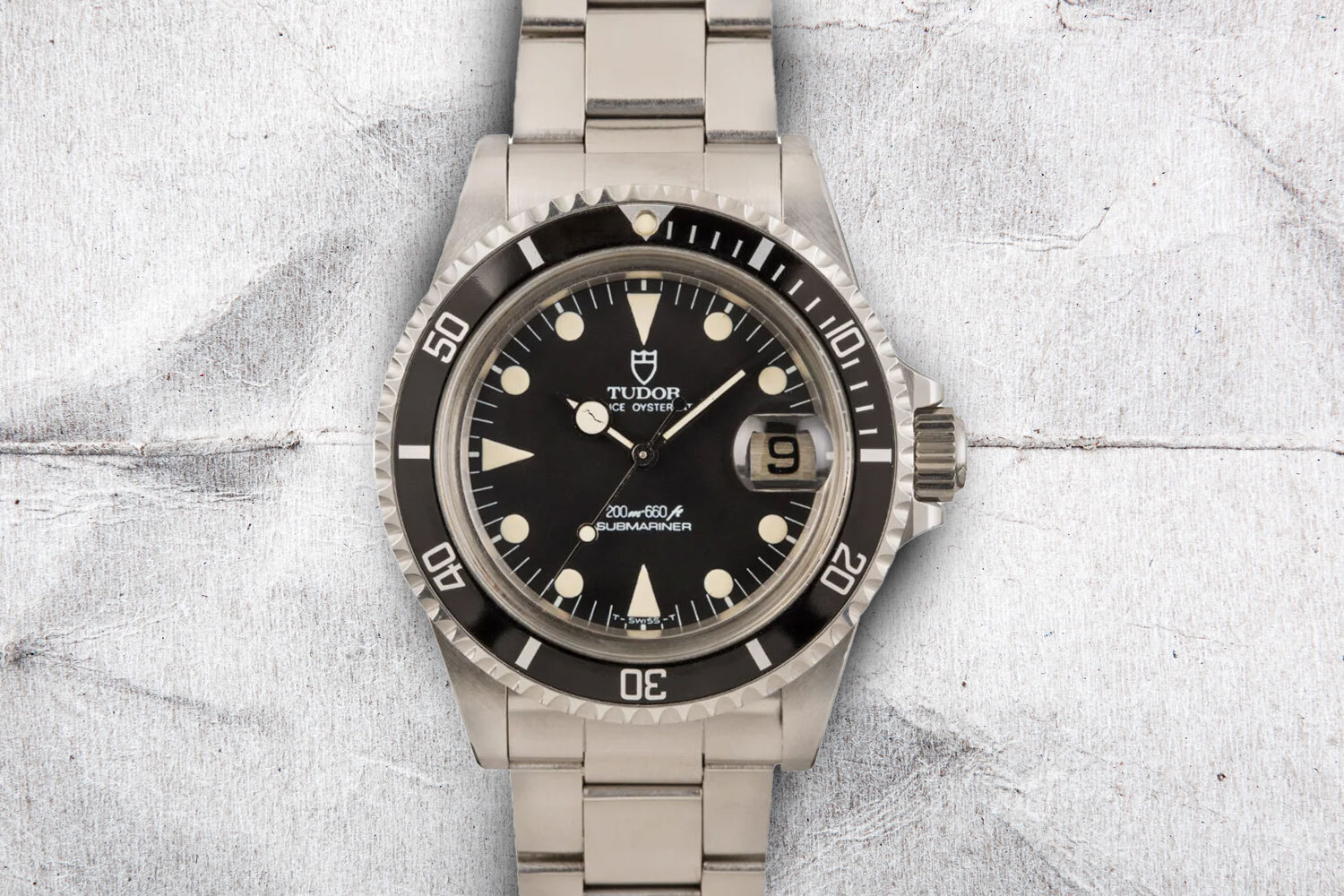 Tudor Submariner, one of the best vintage watches under $10,000, on a gray background.