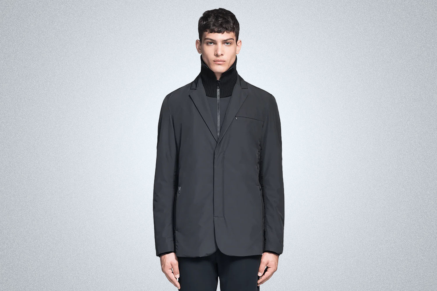 a model in a black Nobis Cody Tailored Travel Blazer on a grey background