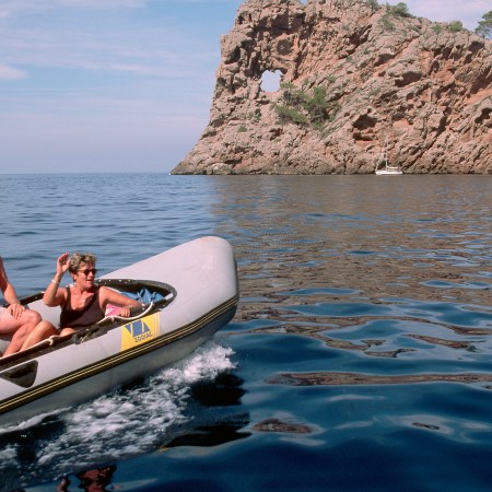 An older couple on a boat in a picturesque body of water. As a new survey shows, being wealthier does make you happier.