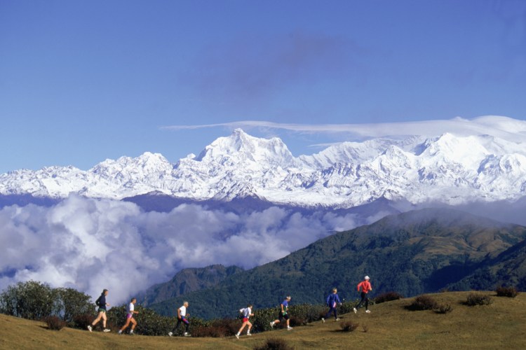 A line of people running in the mountains.
