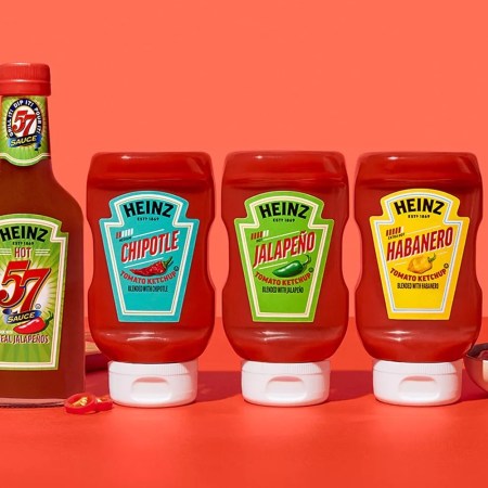 lineup of heinz spicy ketchup and steak sauce with someone dunking a chicken nugget