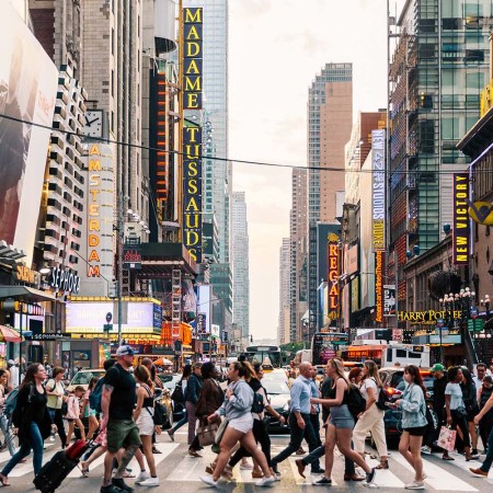 Dozens of people strolling through a crosswalk in New York City