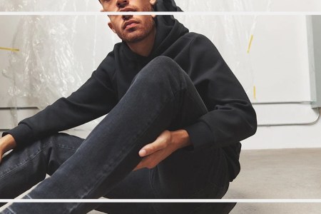 a model wearing DSTLD jeans sitting on a stone floor