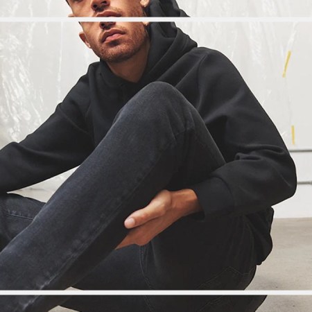a model wearing DSTLD jeans sitting on a stone floor