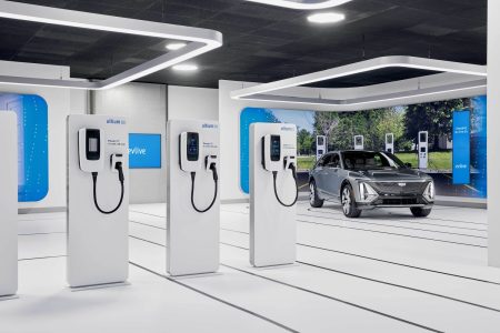 Car chargers lined up with an electric car driving next to it.