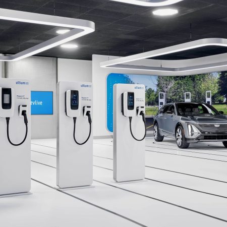 Car chargers lined up with an electric car driving next to it.