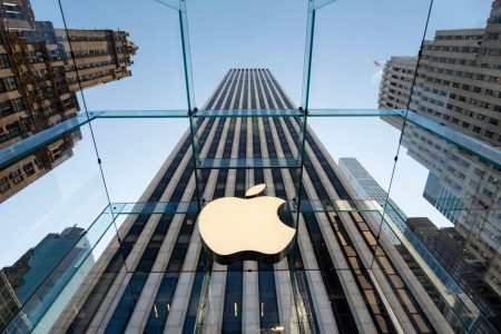 Apple logo on glass city building.