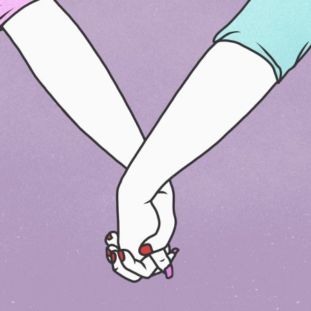 Cropped hands of lesbian couple holding hands against purple background