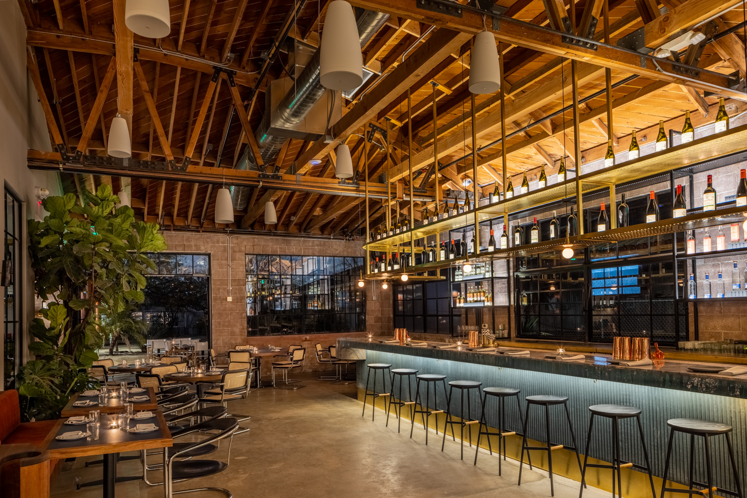 A blue bar at a restaurant with empty seats in dim lighting.